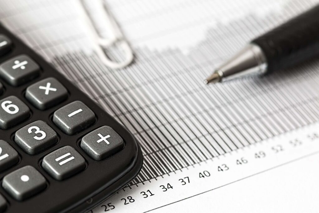 closeup of a printed chart with a pen and calculator