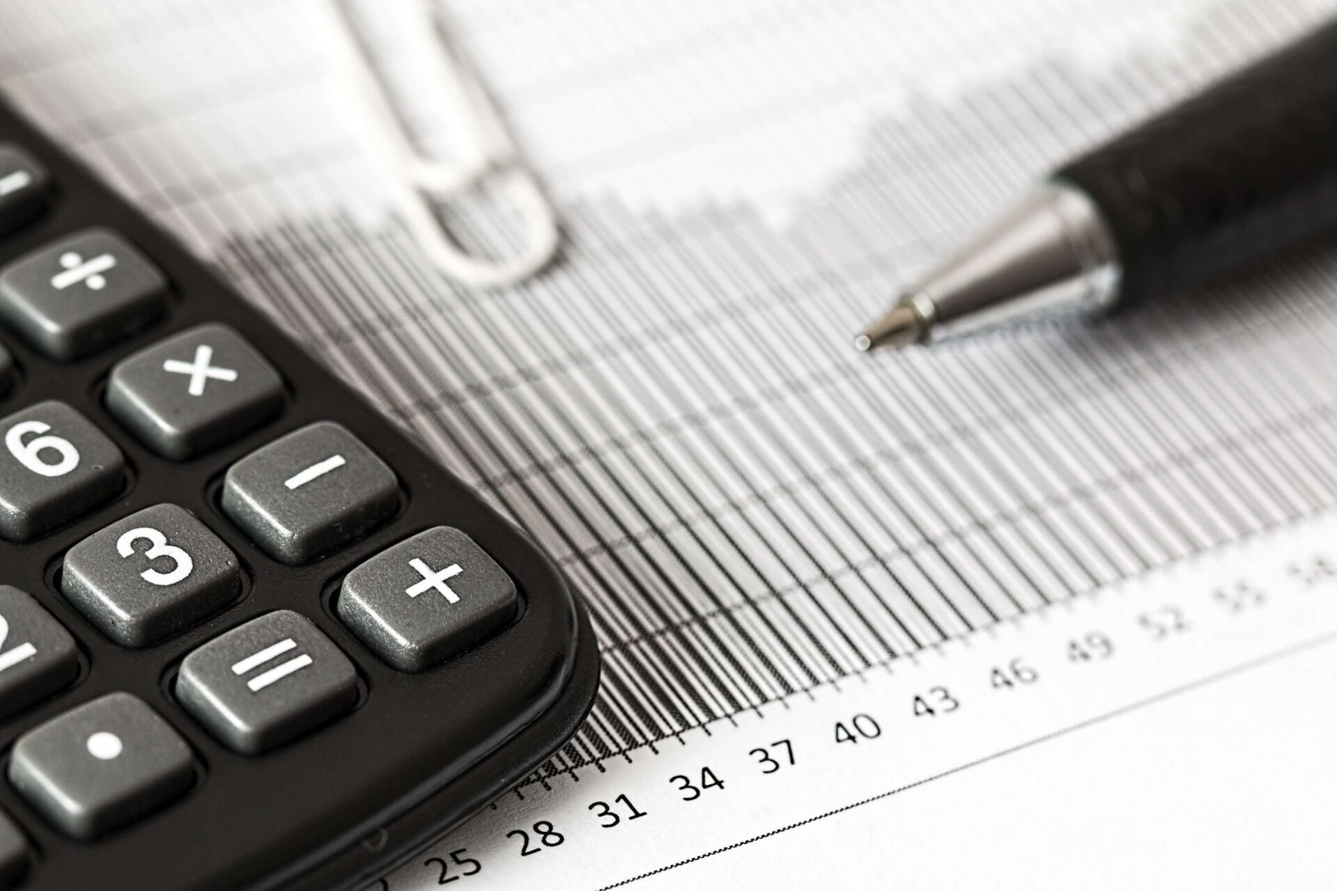 closeup of a printed chart with a pen and calculator