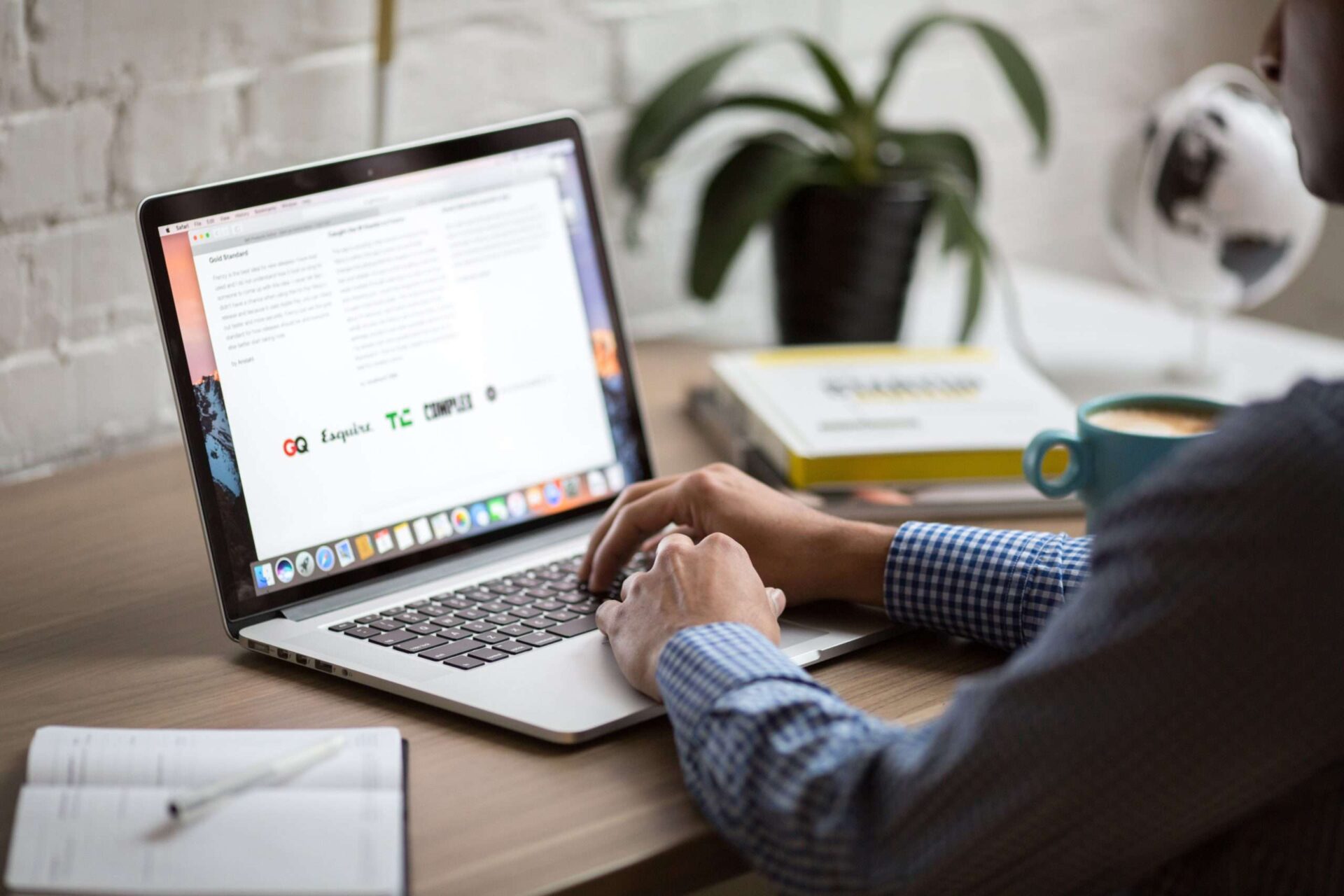 Closeup of a man working at a laptop on his desk