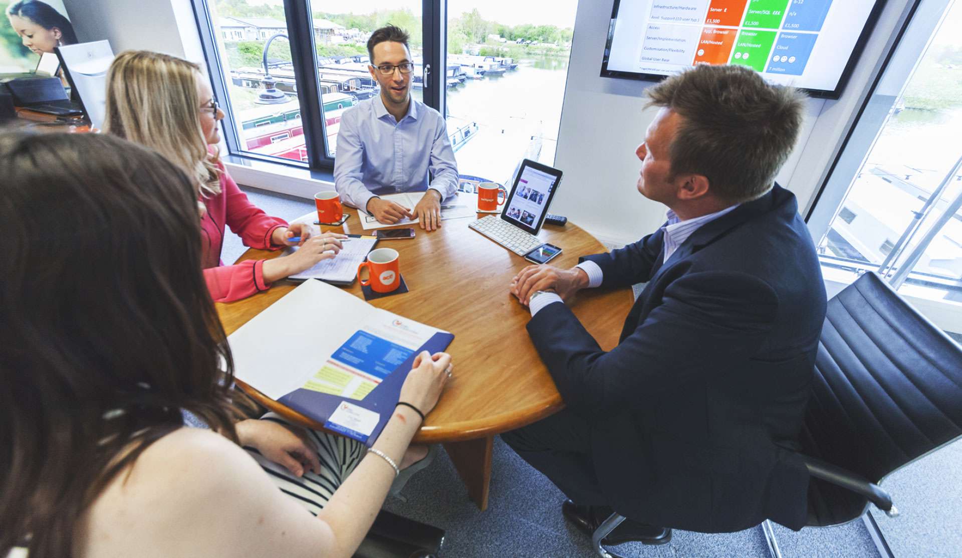 Solutions employees in the Derby office meeting around a table