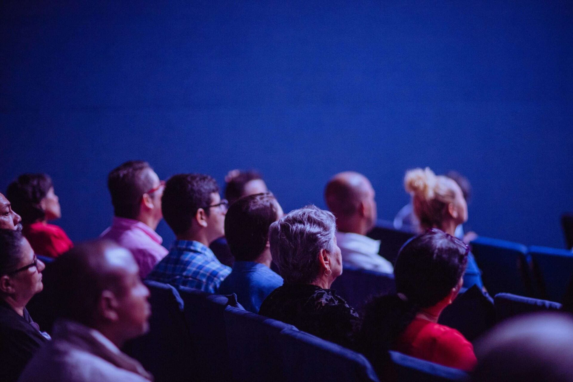 Crowd of people sitting in an audience watching something