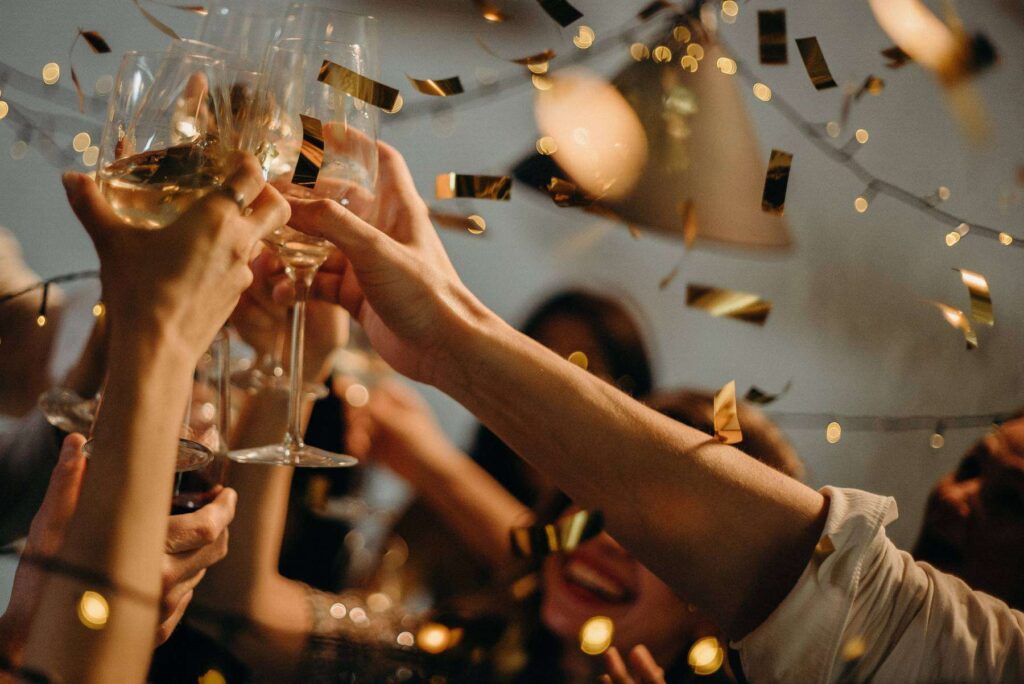 Close up of a celebration with several people clinking their wine glasses together