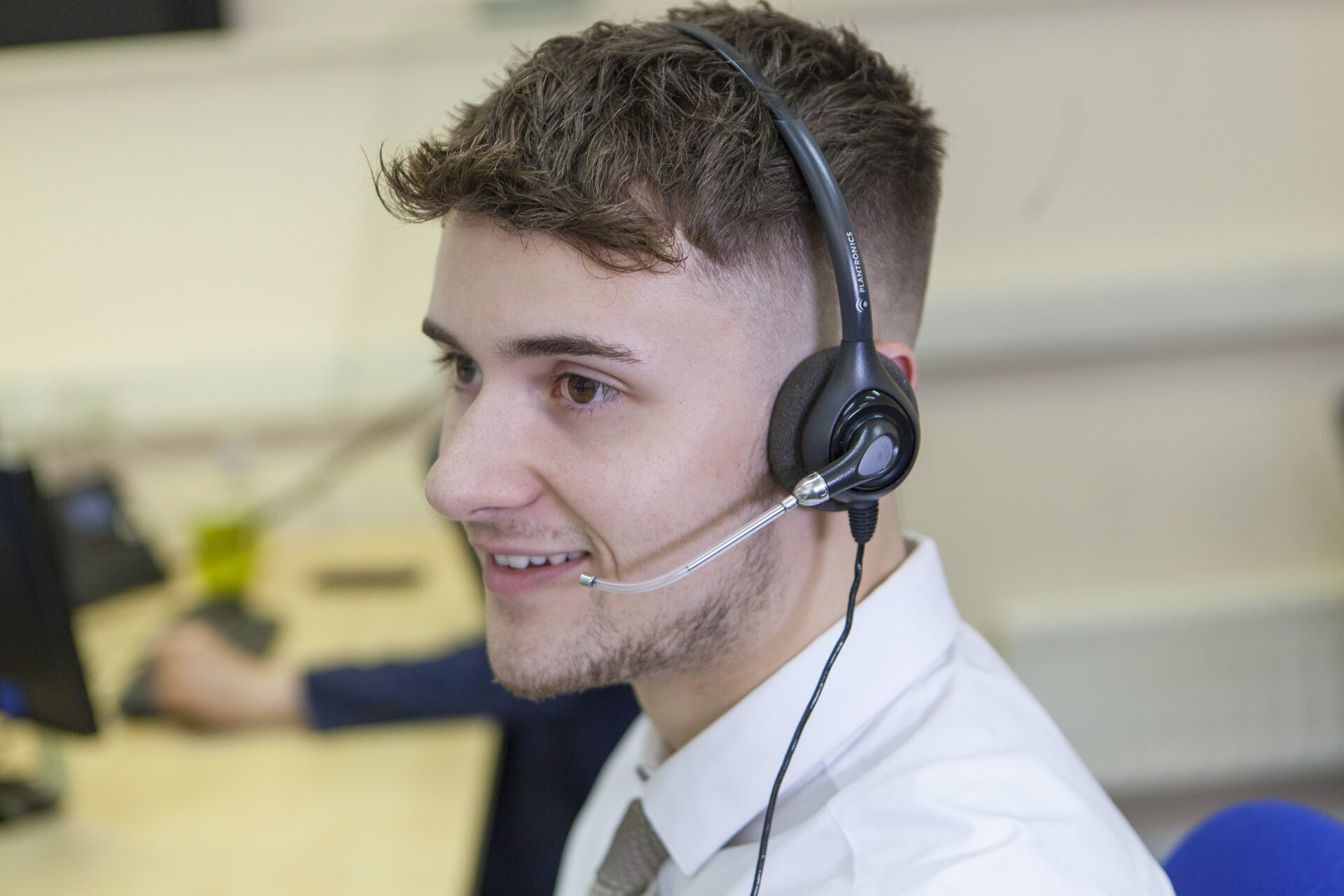 Solutions employee, George, wearing a headset and speaking with a customer on the phone