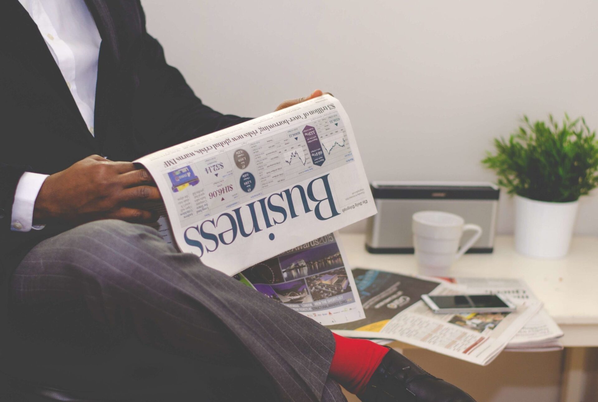 A man in a suit reading a business newspaper