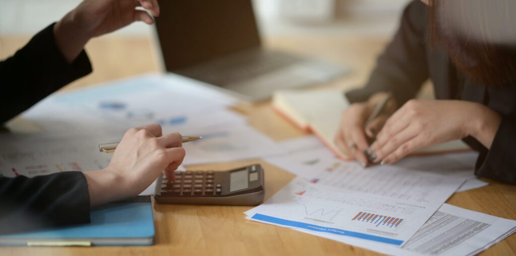 closeup of hands laying on printouts and a calculator during a meeting