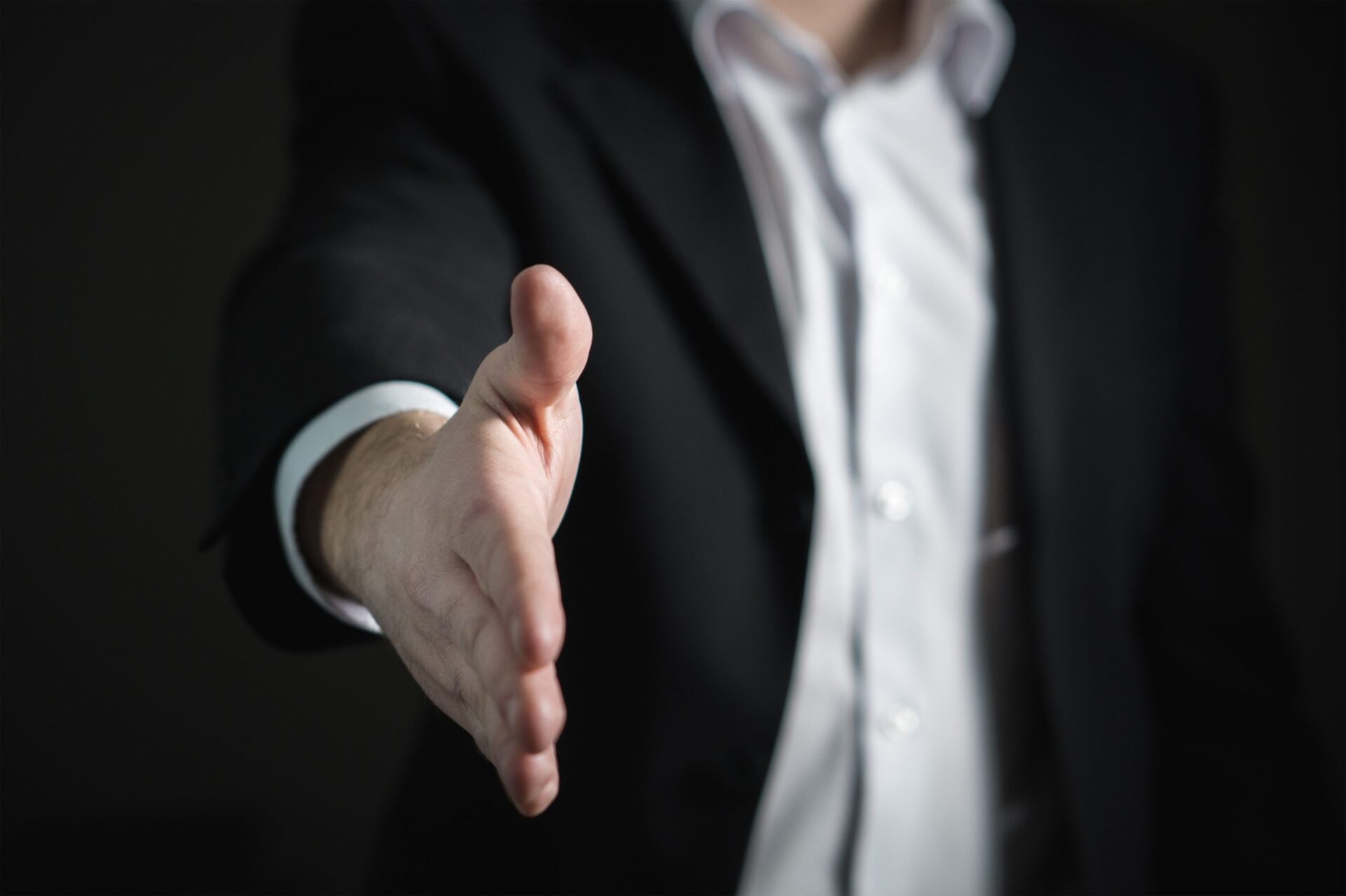 Closeup of a mans hand reaching out for a handshake