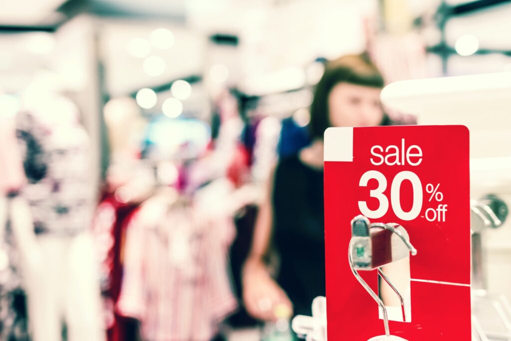 Inside clothing shop with a large red sign reading Sale 30% off