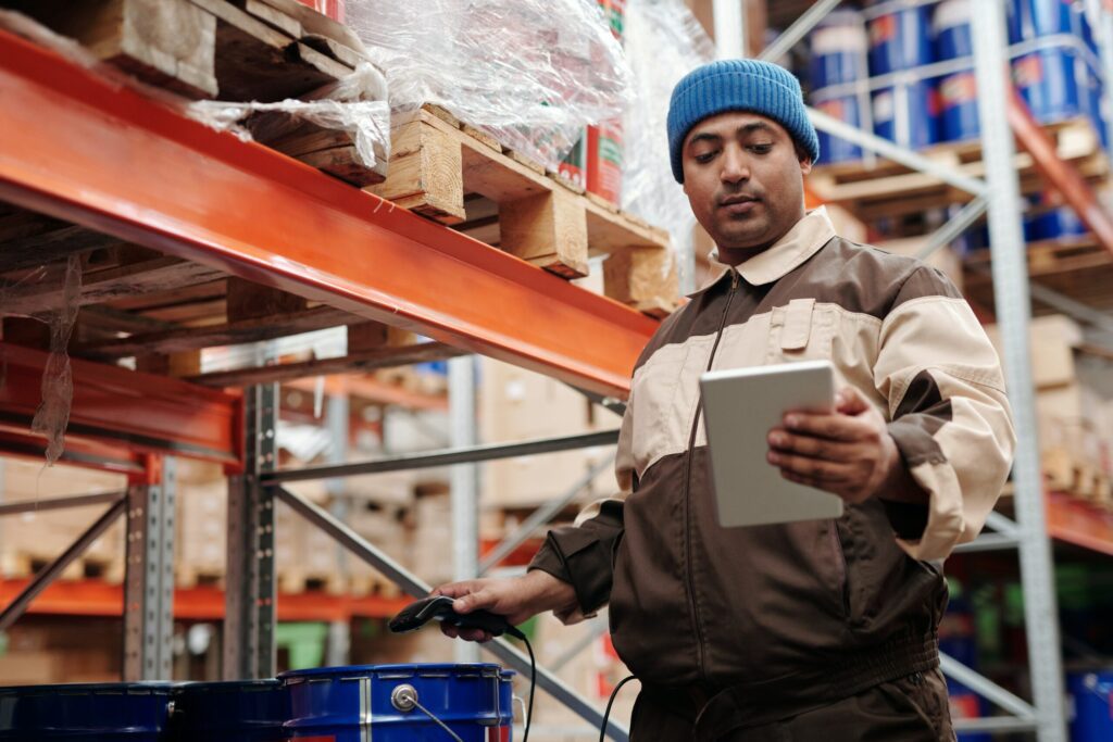 A warehouse worker scanning an item and checking it on his tablet