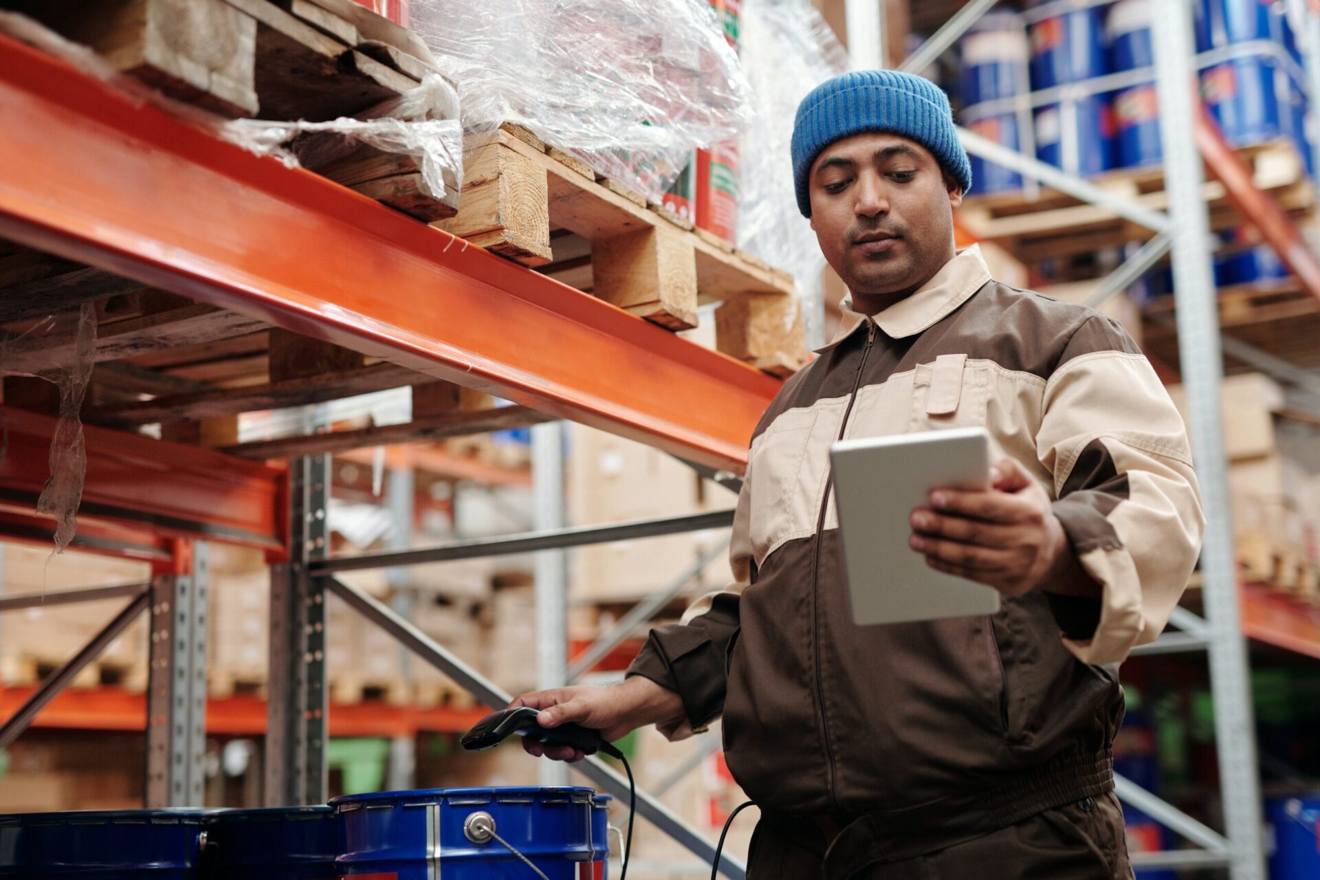 A warehouse worker scanning an item and checking it on his tablet