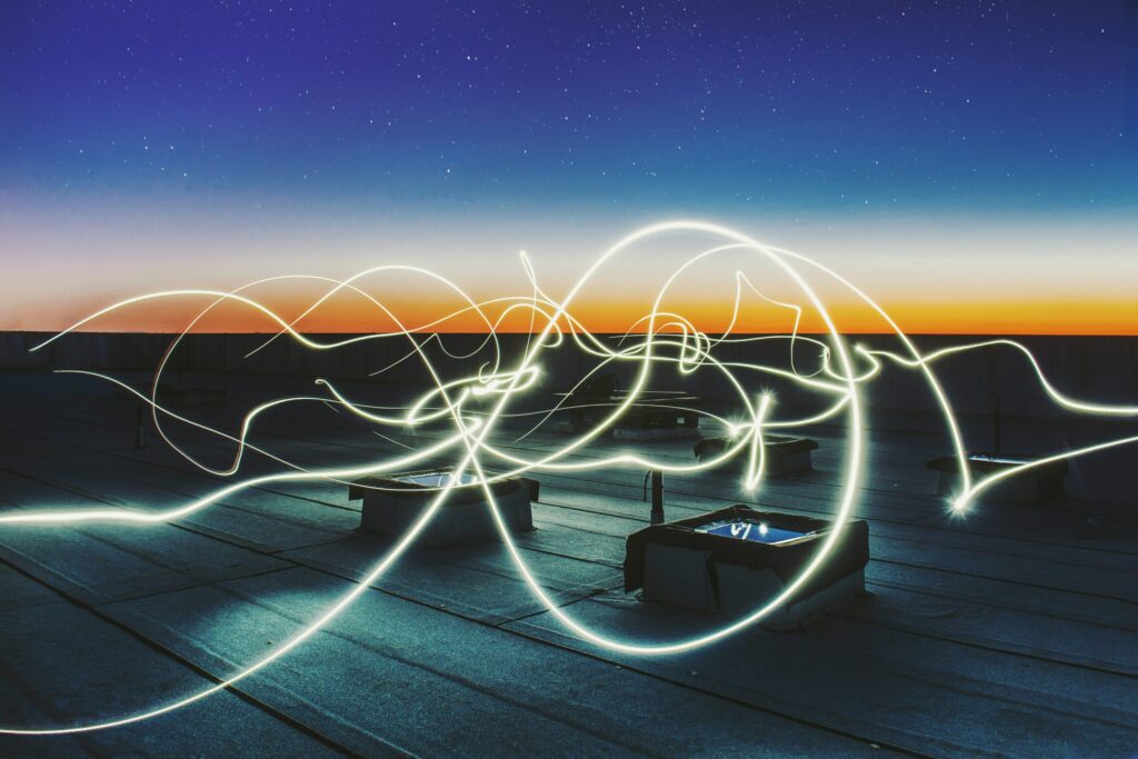 Long exposure of a bright light passing over a rooftop