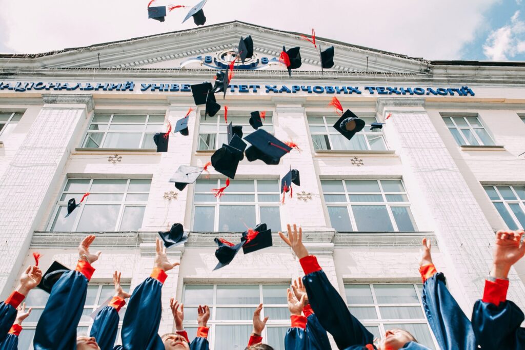 Low shot of a group of graduates throwing their caps in the air in celebration