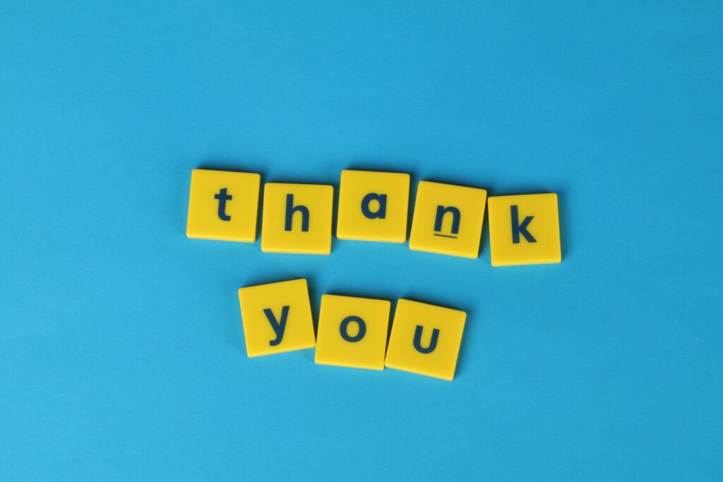 Thank you spelled out with yellow letter blocks on a blue background