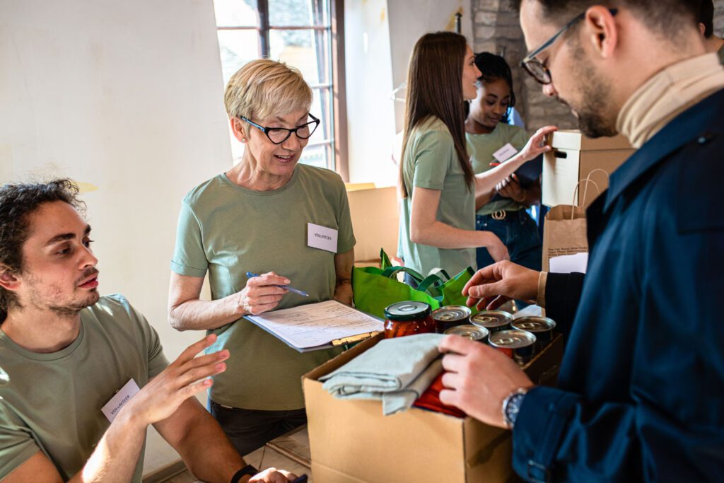 Smiling volunteer at a food bank speaking with someone