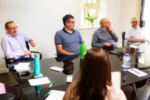 Employees having a meeting around a table at Solutions for Accounting head office