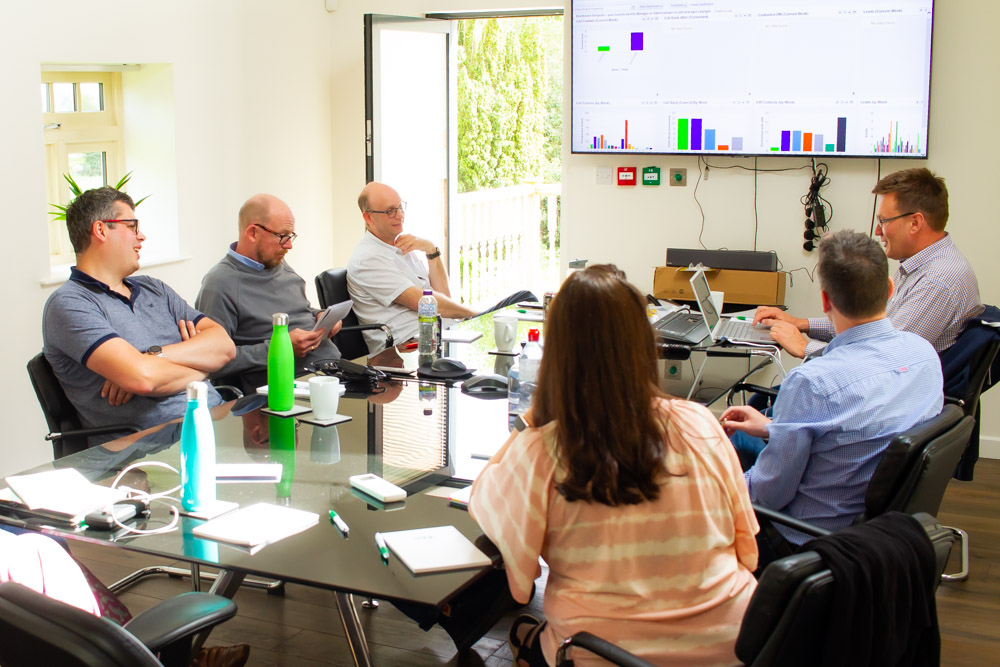 Employees having a meeting around a table at Solutions for Accounting head office
