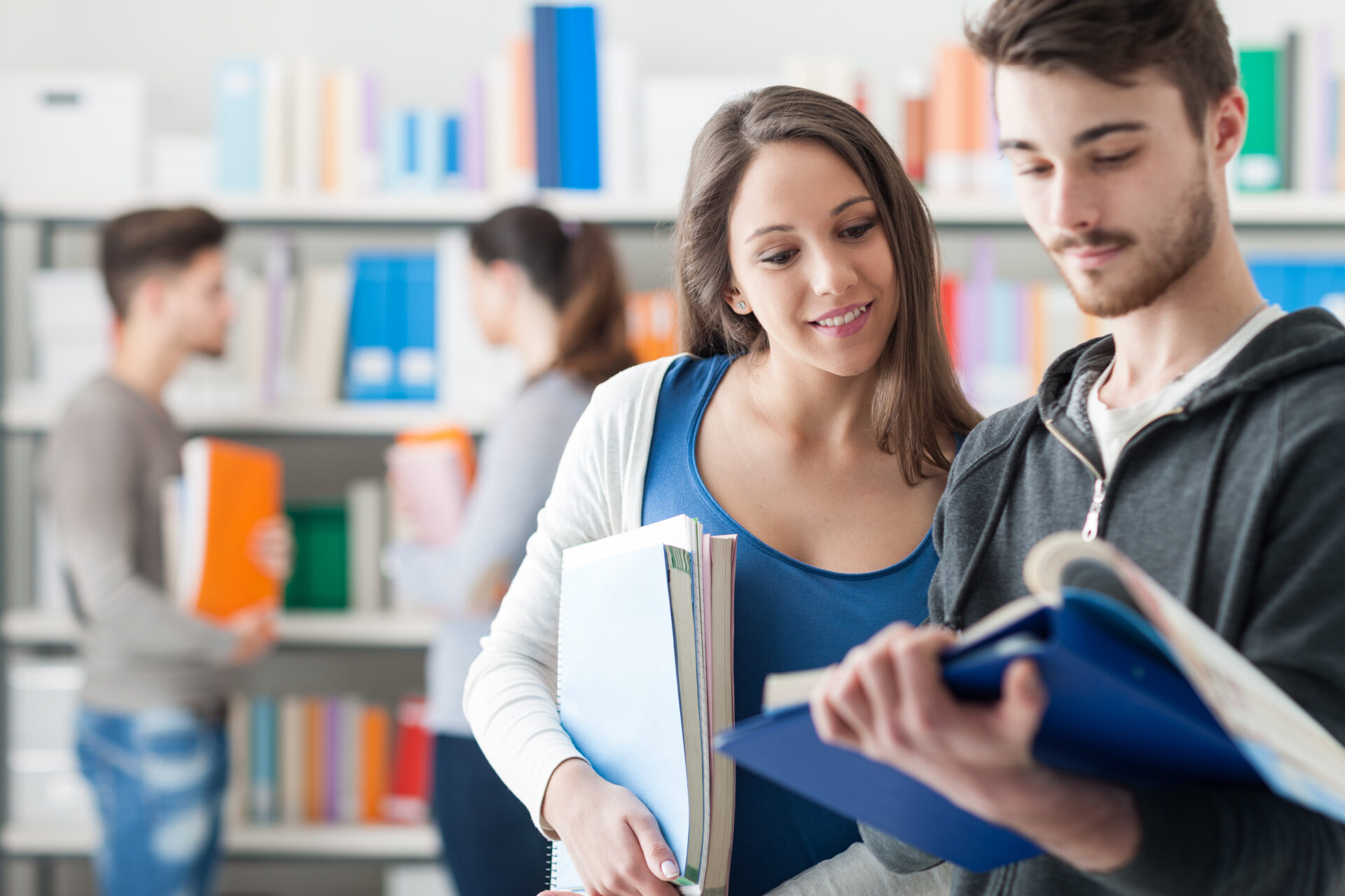 Two students looking at notes in a library
