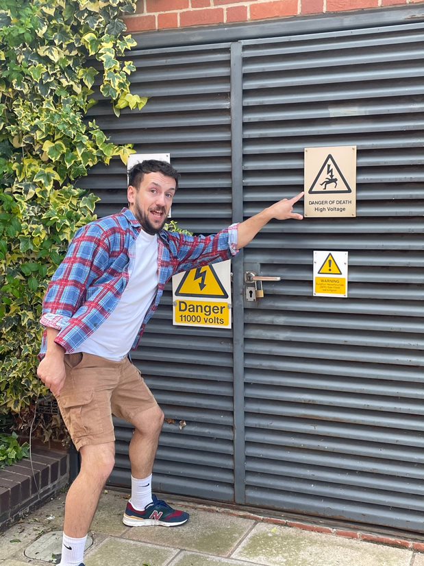 Solutions employee poitnign at a warning sign as part of a scavenger hunt