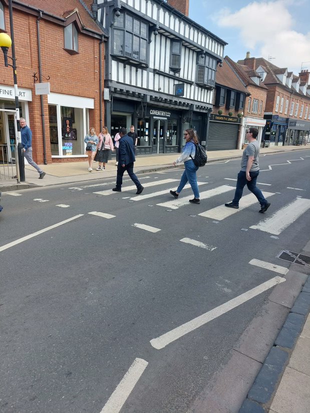 Solutions employees crossing a zebra crossing for a photo as part of a scavenger hunt