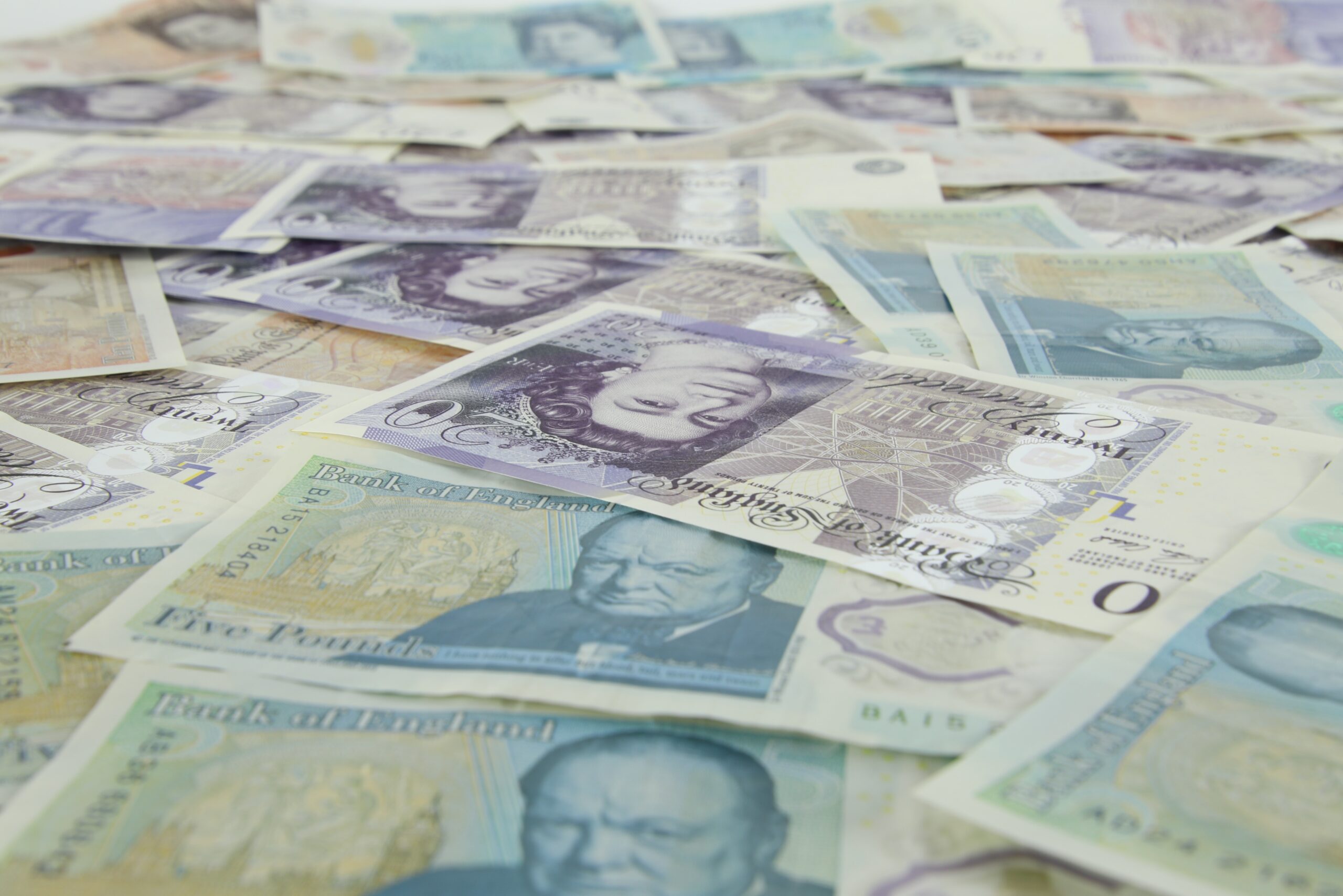 Lots of English bank notes of different denominations covering a floor