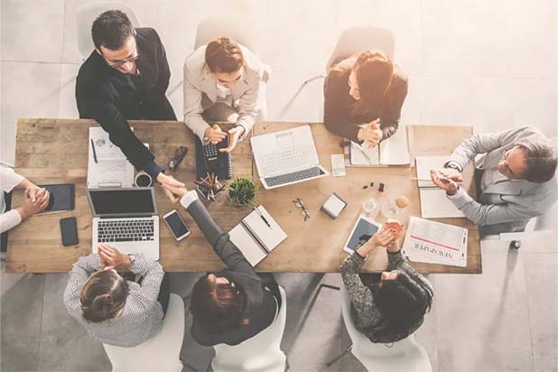top down view of business people shaking hands in an office