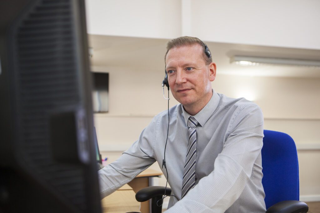 Michael working at a computer wearing a headset