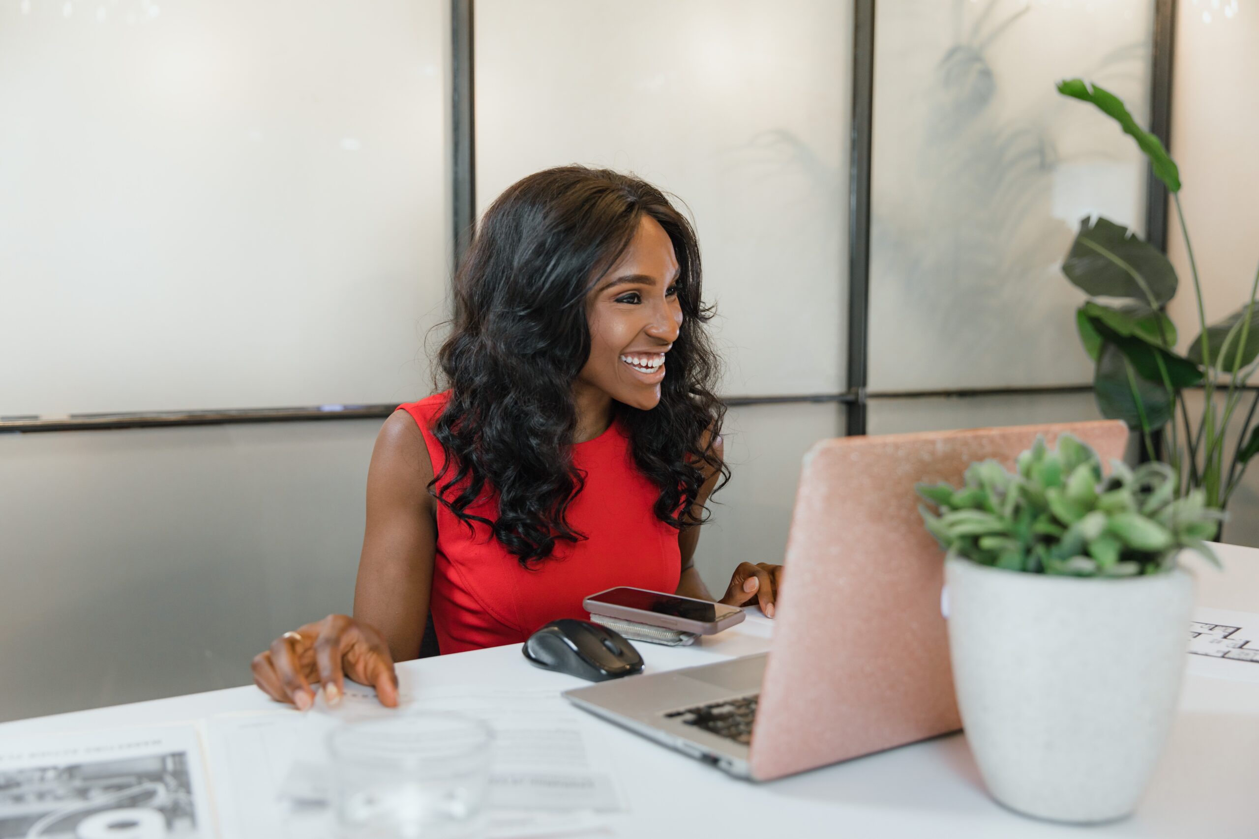 Smiling woman working at a laptop in a clean office
