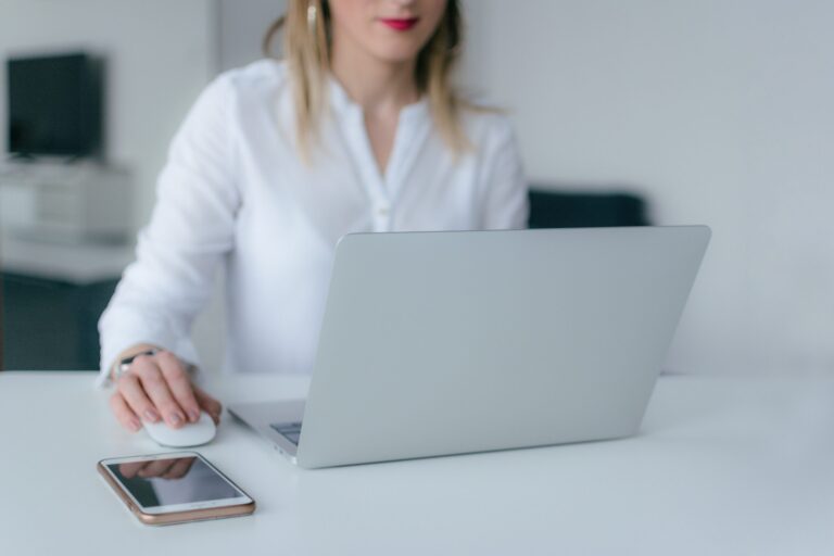 Woman working at a laptop on a clean white desk