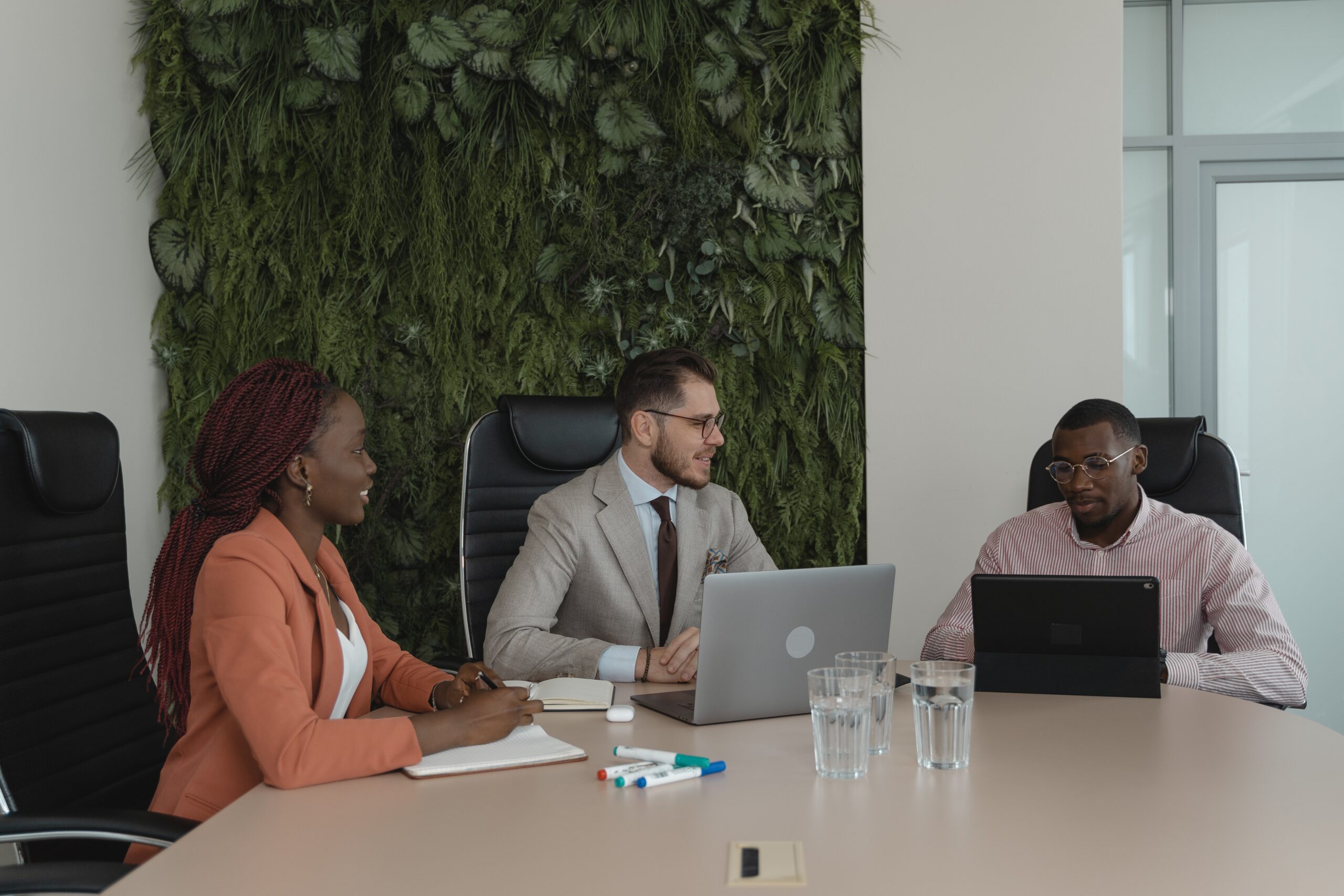 small business meeting with three people sitting at a desk in an office