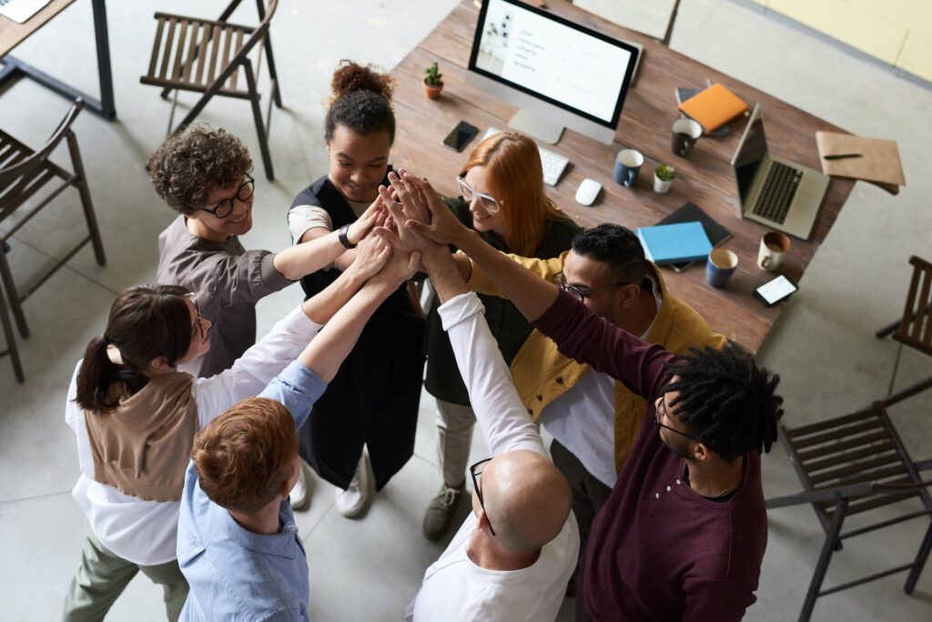 Group of young businesspeople high-fiving in an open plan office