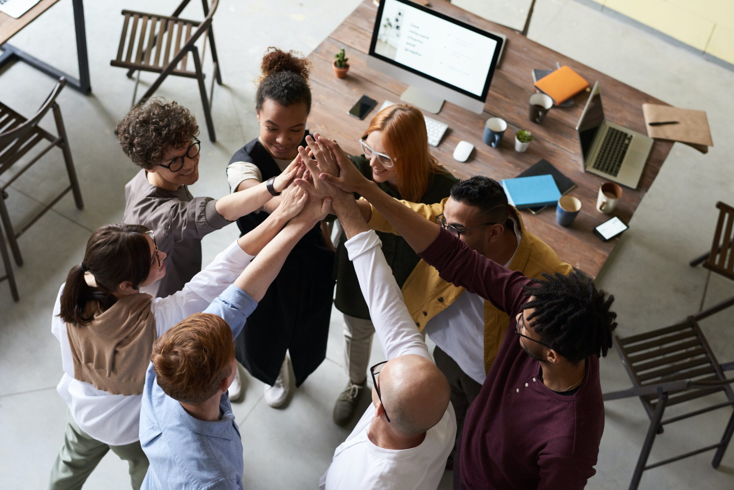Group of young businesspeople high-fiving in an open plan office