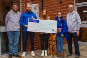 Staff members of Solutions for Accounting presenting members of Support Dogs with a cheque