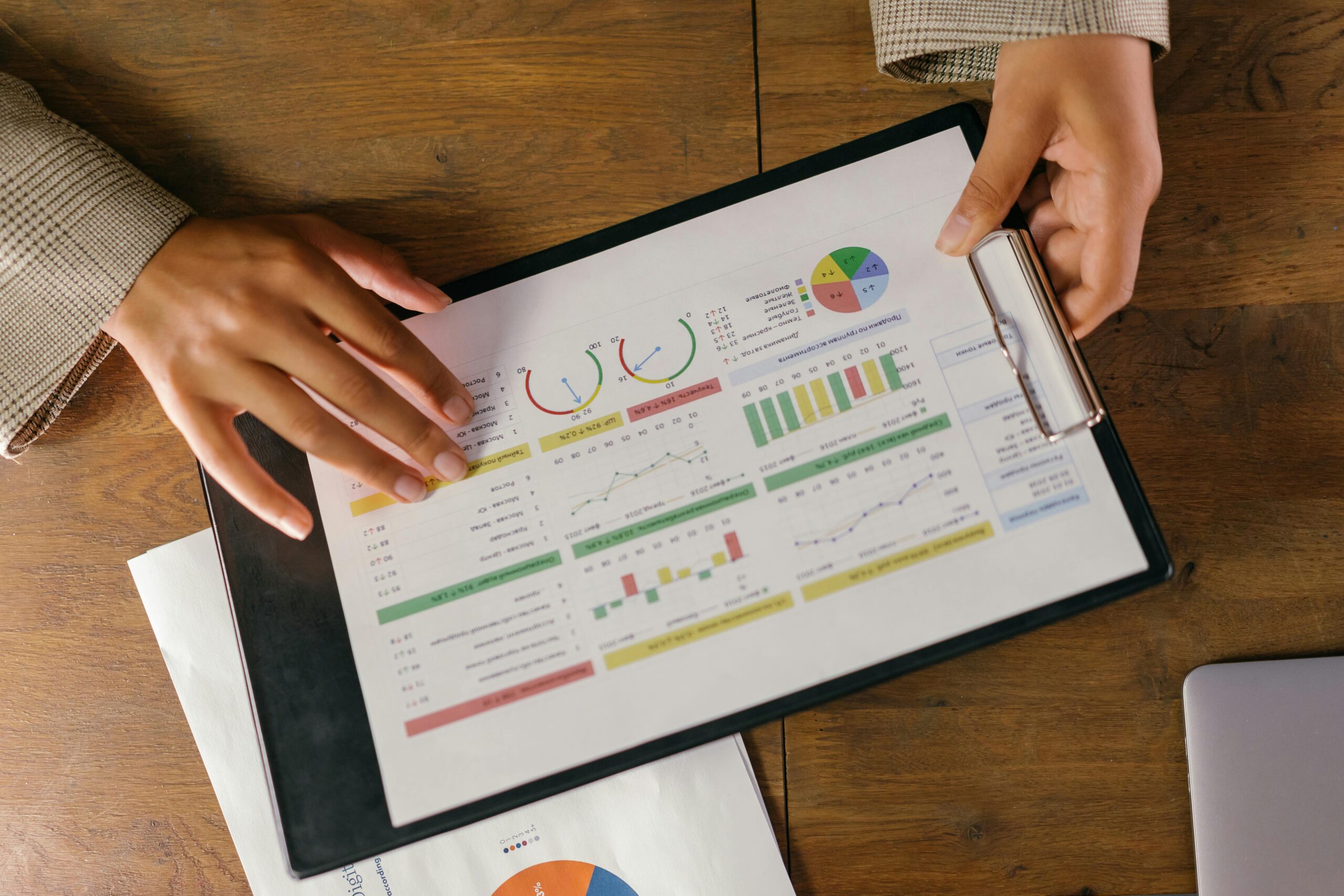 Closeup of someone holding a clipboard with a printout of graphs and charts