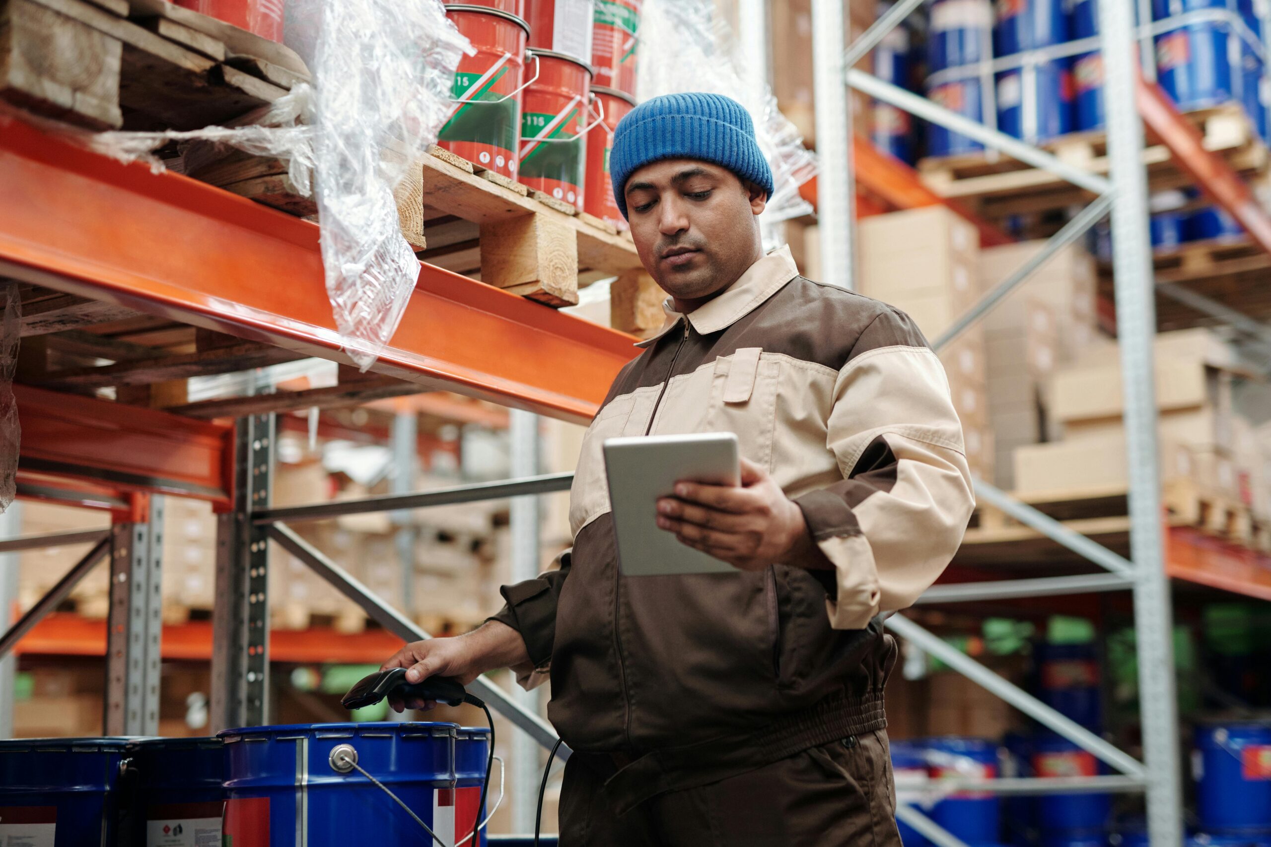 wholesale warehouse with a worker checking an item of inventory with a scanner