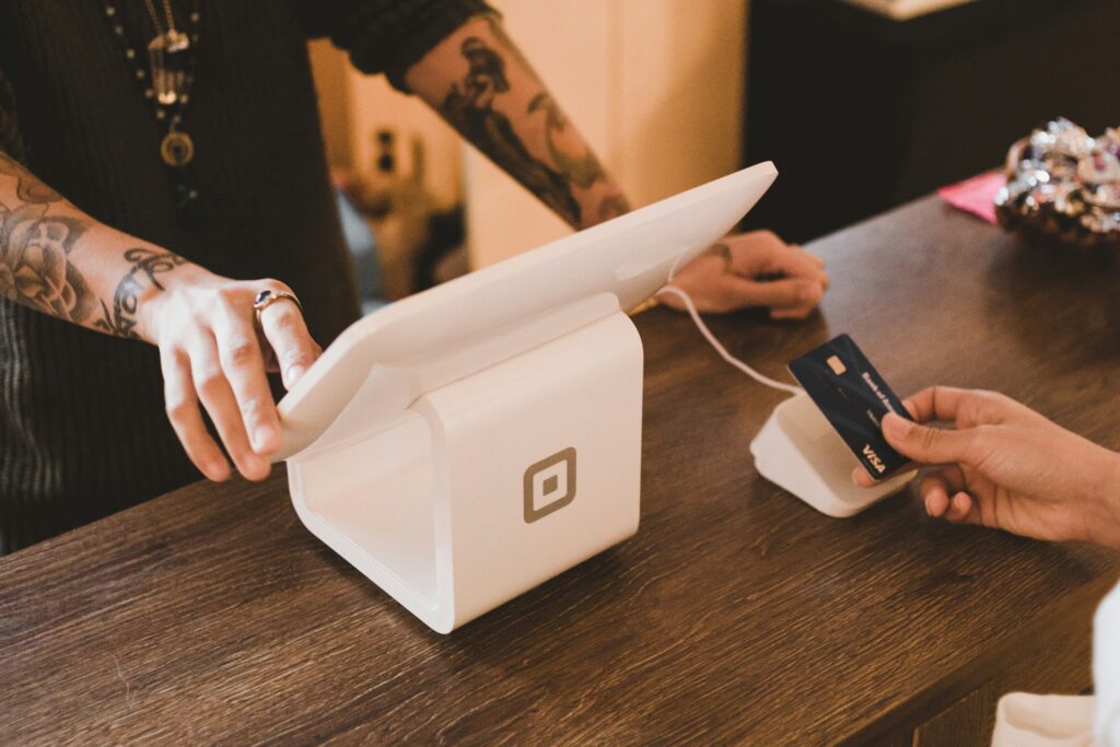 Person paying by card at checkout of a retail business