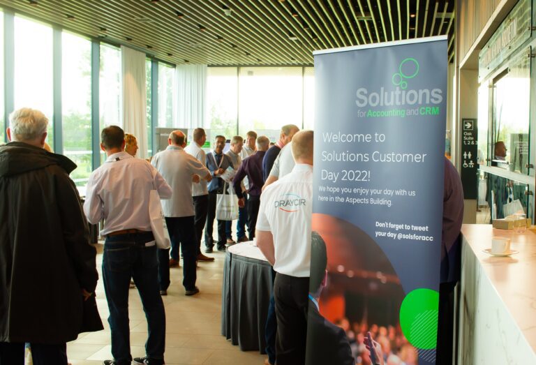Entry to Solutions for Accounting Customer Day 2022 with a banner and a room full of people