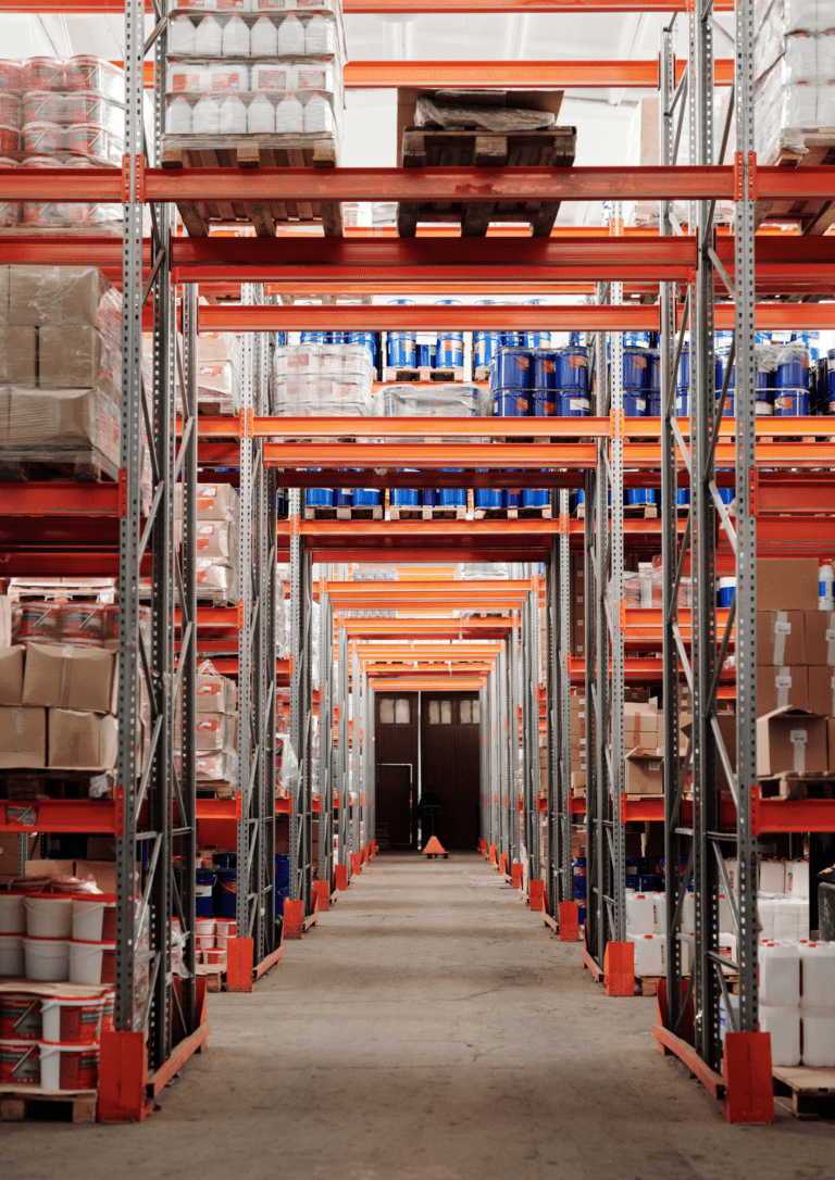 Vertical photo of a warehouse showing dozens of shelves packed high with inventory