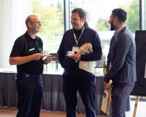 Iain Barker speaking to two attendees of the Solutions Showcase 2024