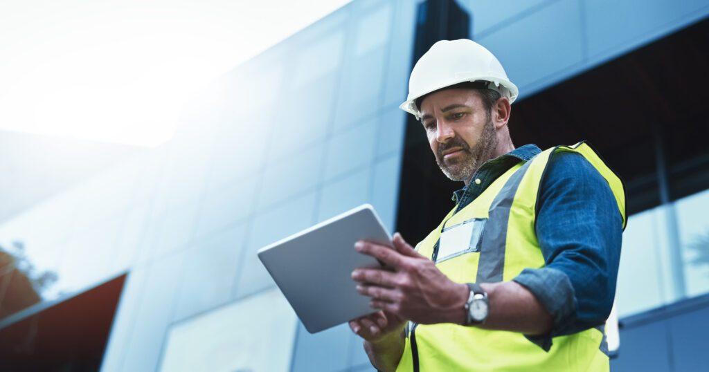 Sage Intacct for Construction - Shot of a engineer using a digital tablet on a construction site