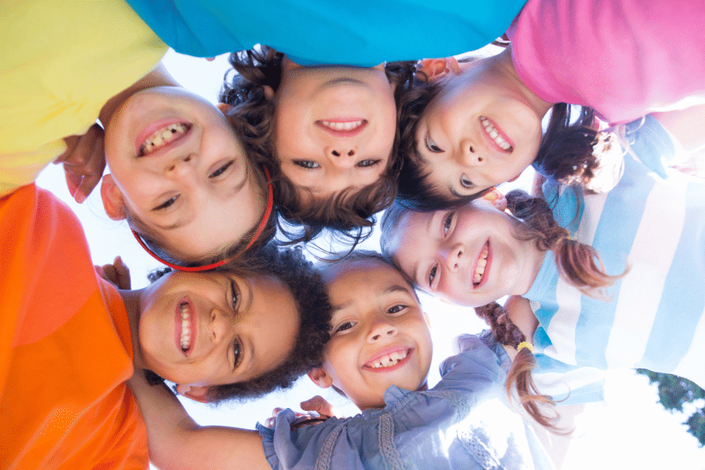 Upwards photo f a group of children grouped together and looking down