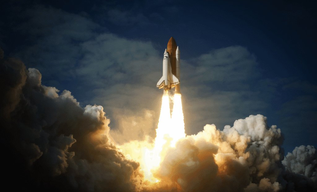 A space shuttle rockets upwards into the sky with a large plume of fire and smoke underneath it.