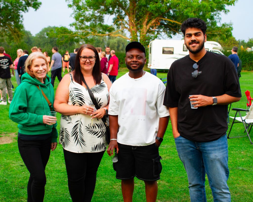 Four Solutions employees standing, smiling at the camera