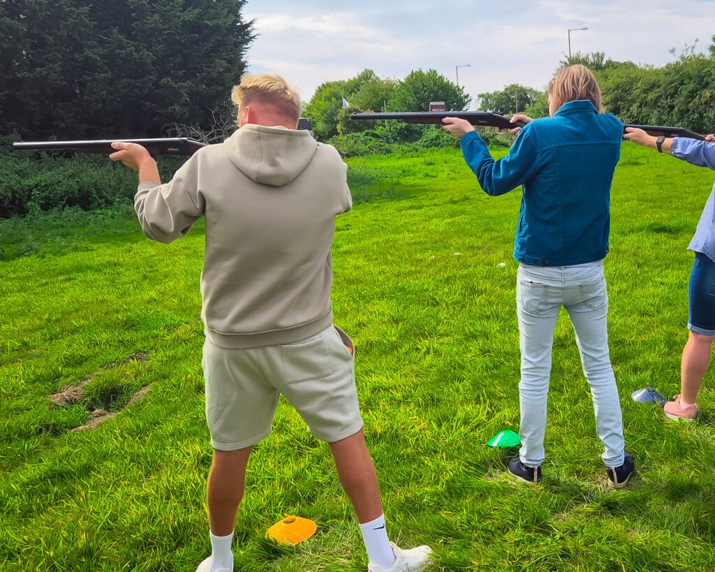 A group of Solutions for Accounting employees and their partners doing laser clay pigeon shooting at the Mystery Weekend Away 2025