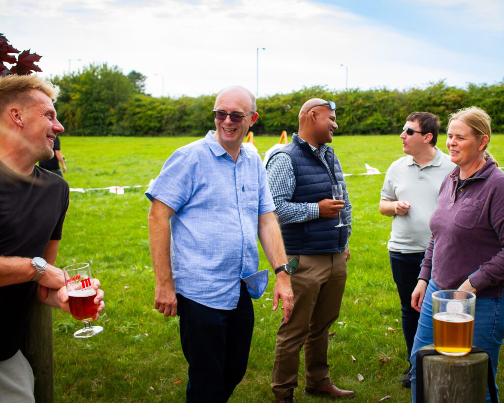 Iain Barker smiling and talking with employees at the Mystery Weekend Away