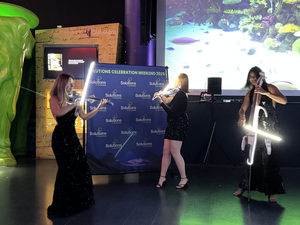 Performers from Azul Strings, a luxury string quartet, stand and play in formal attire.