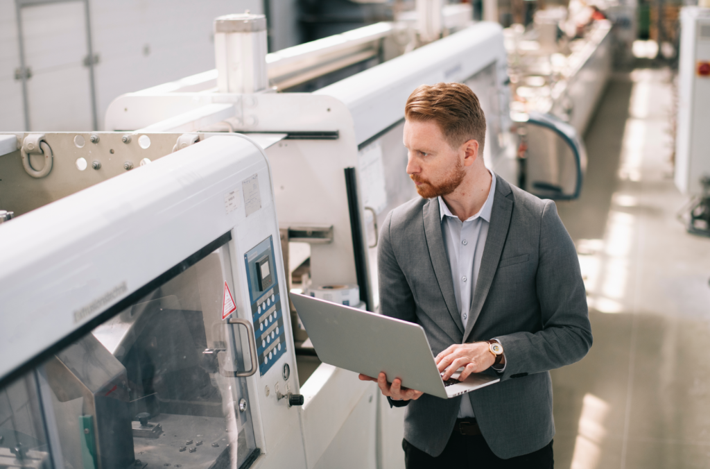 An employee inspecting machinery in a factory