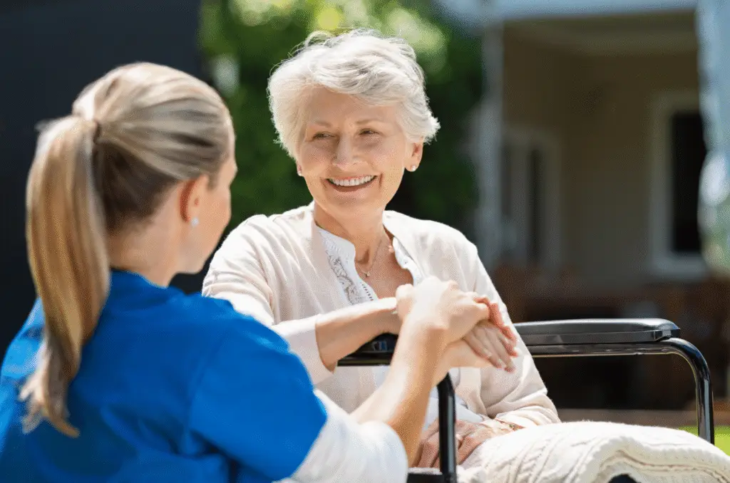 Country Court Care Home image showing an elderly woman in a wheelchair speaking to a carer