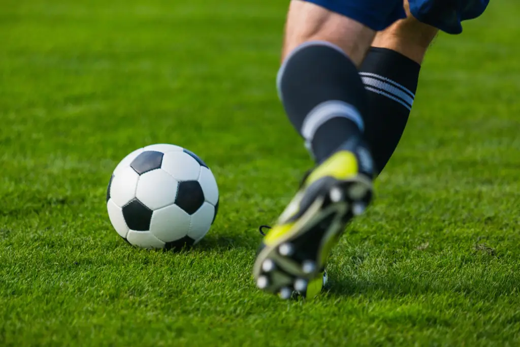 A close-up shot of a football player kicking a ball.