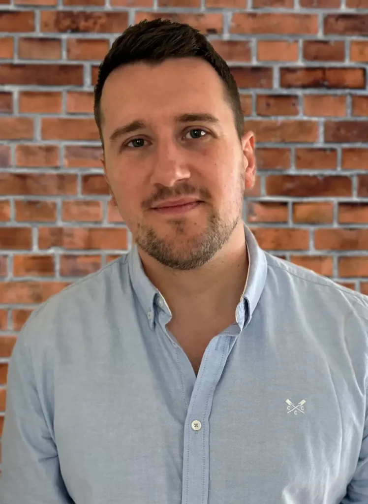 Colour photo of Solutions for Accounting employee Ryan Gryniewicz against a brick wall background