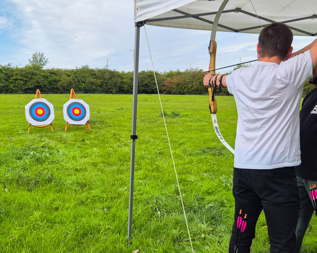 Photo of a Solutions for Accounting employee doing archery at a weekend away