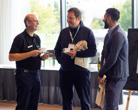 Iain Barker speaking to two attendees of the Solutions Showcase 2024